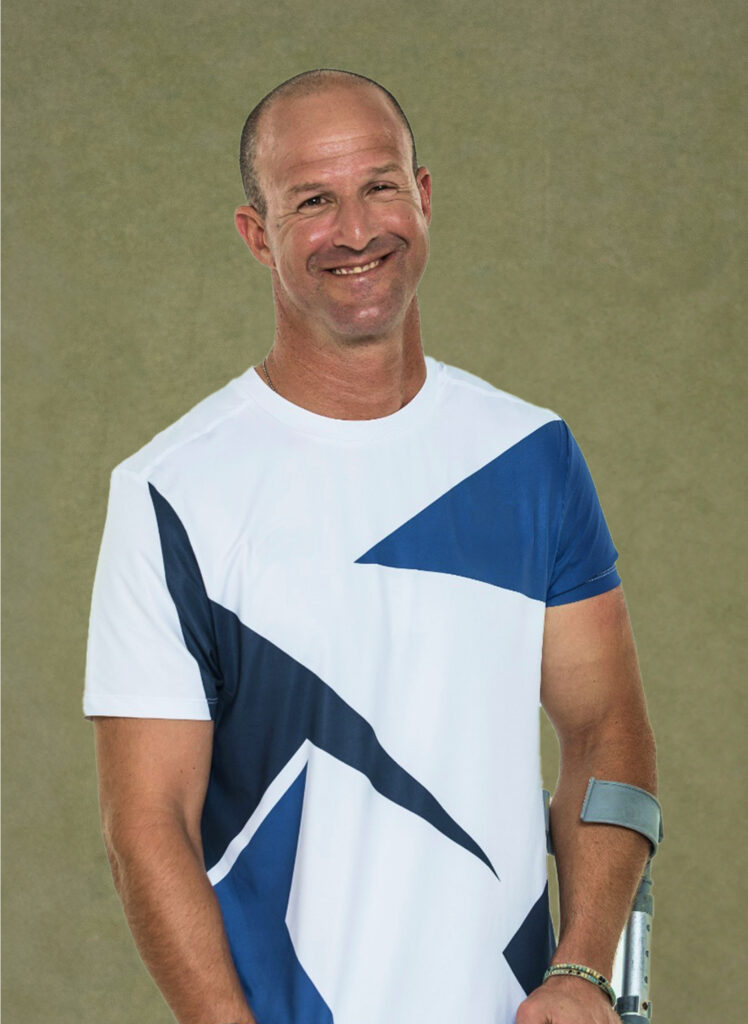 Amit Hasdai, a male athlete with a beaming smile, wearing a white and blue sports shirt. Suitable for video editors and content creators needing engaging footage for royalty-free music videos.