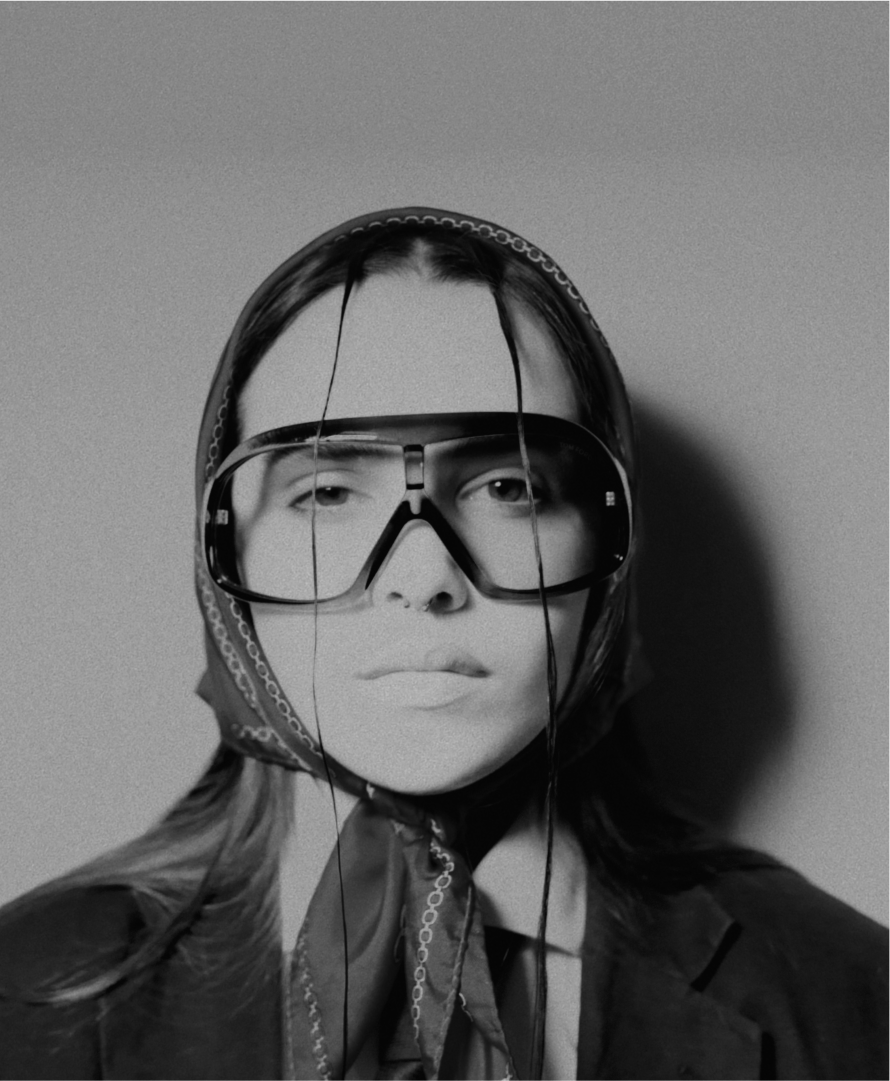 A close-up fashionable style shot of a woman wearing a scarf and glasses.